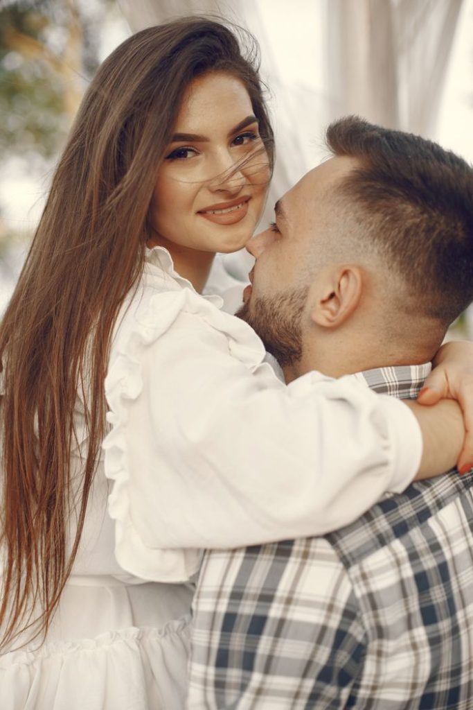 Happy couple embracing in an outdoor setting, showcasing love and connection.